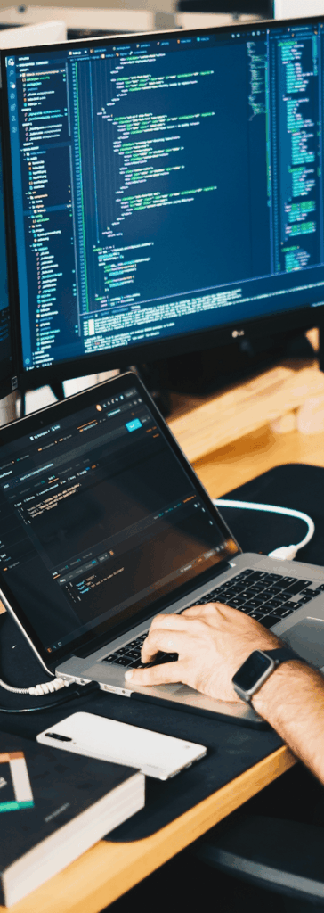 person using a laptop and dual monitor