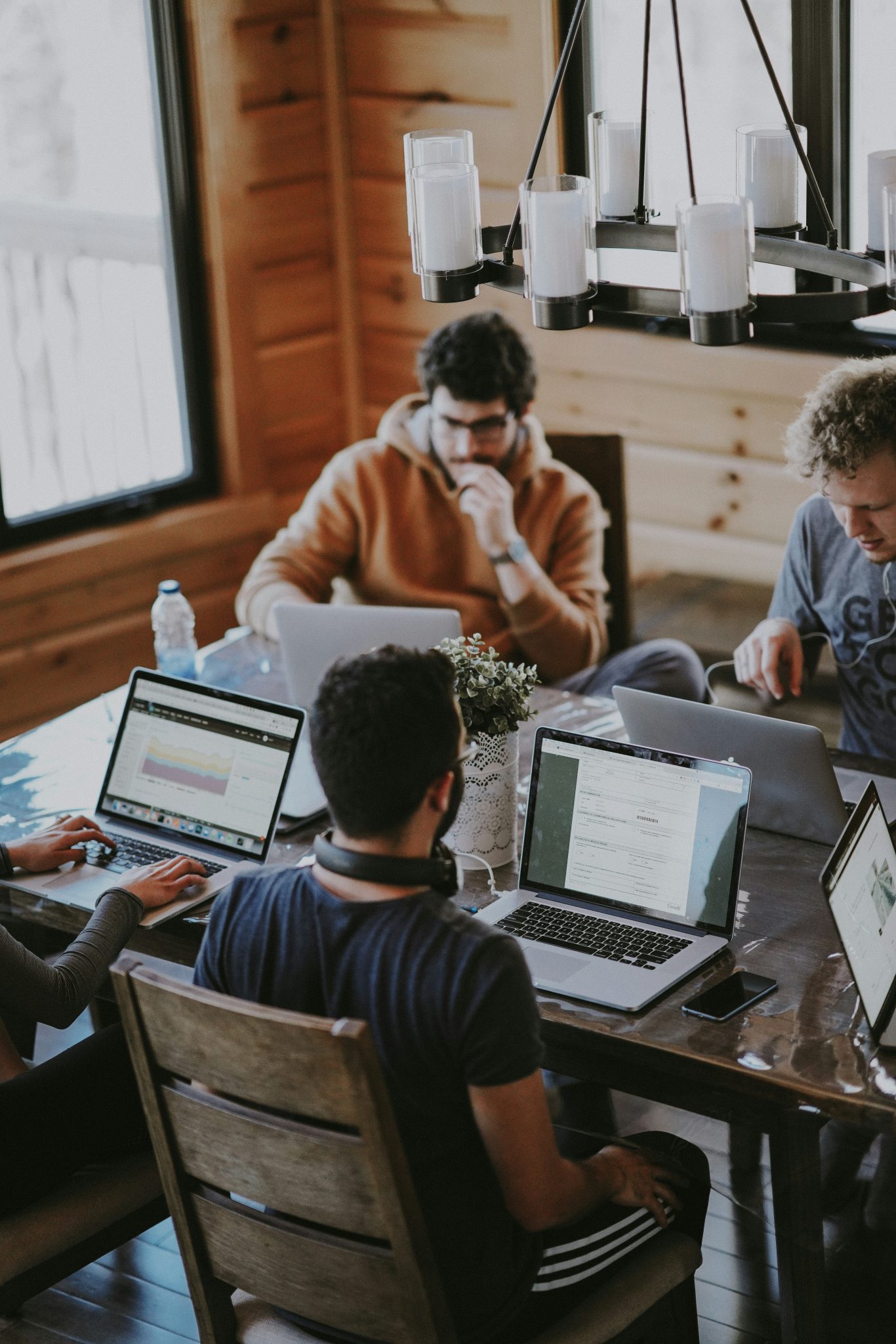 people sitting at a table with open laptops