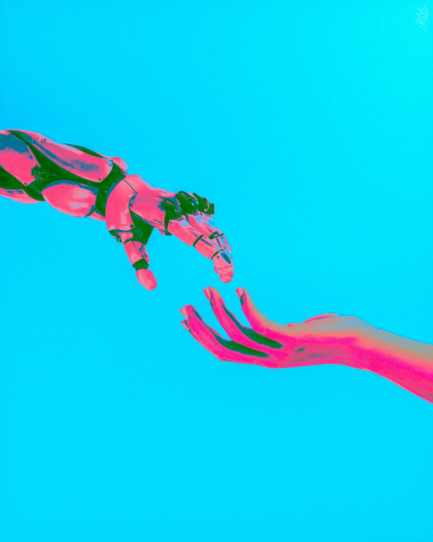 neon pink robot hand and a human hand about to touch against a cyan background