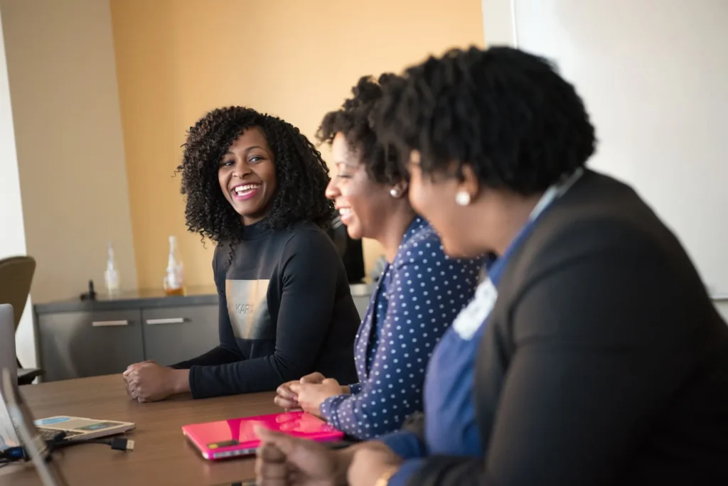 three women at a desk smiling