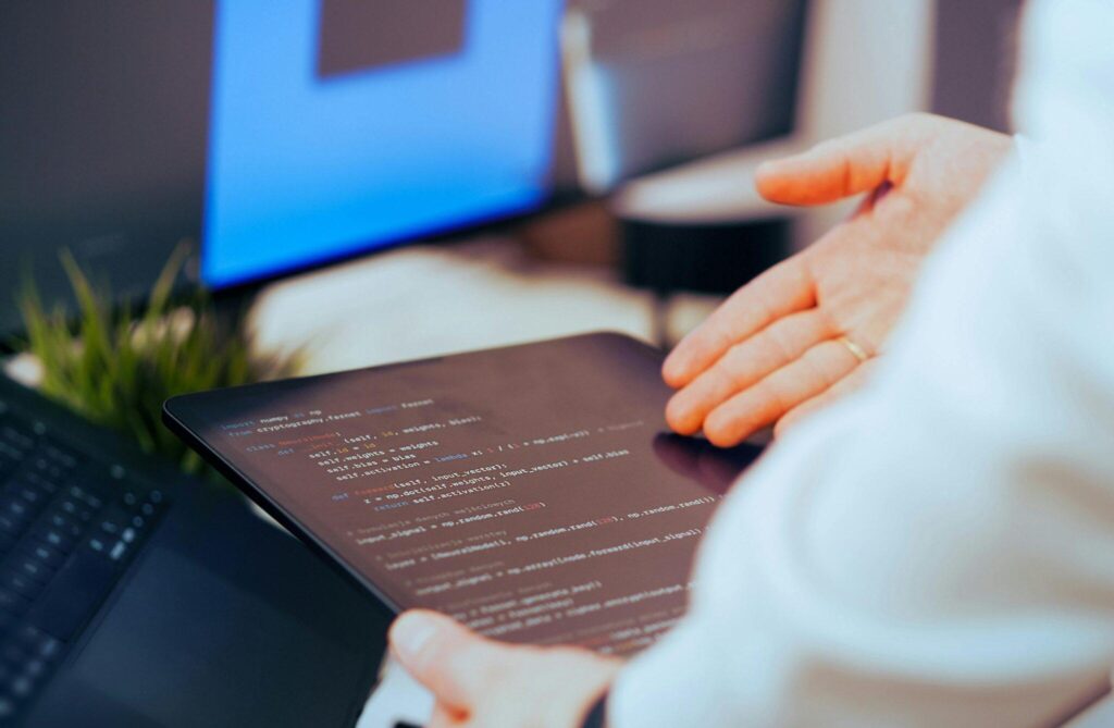 closeup of hand gesturing to tablet with code