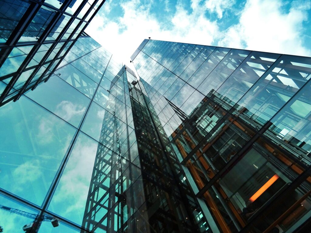 worms eye view of glass-front buildings and cloudy sky