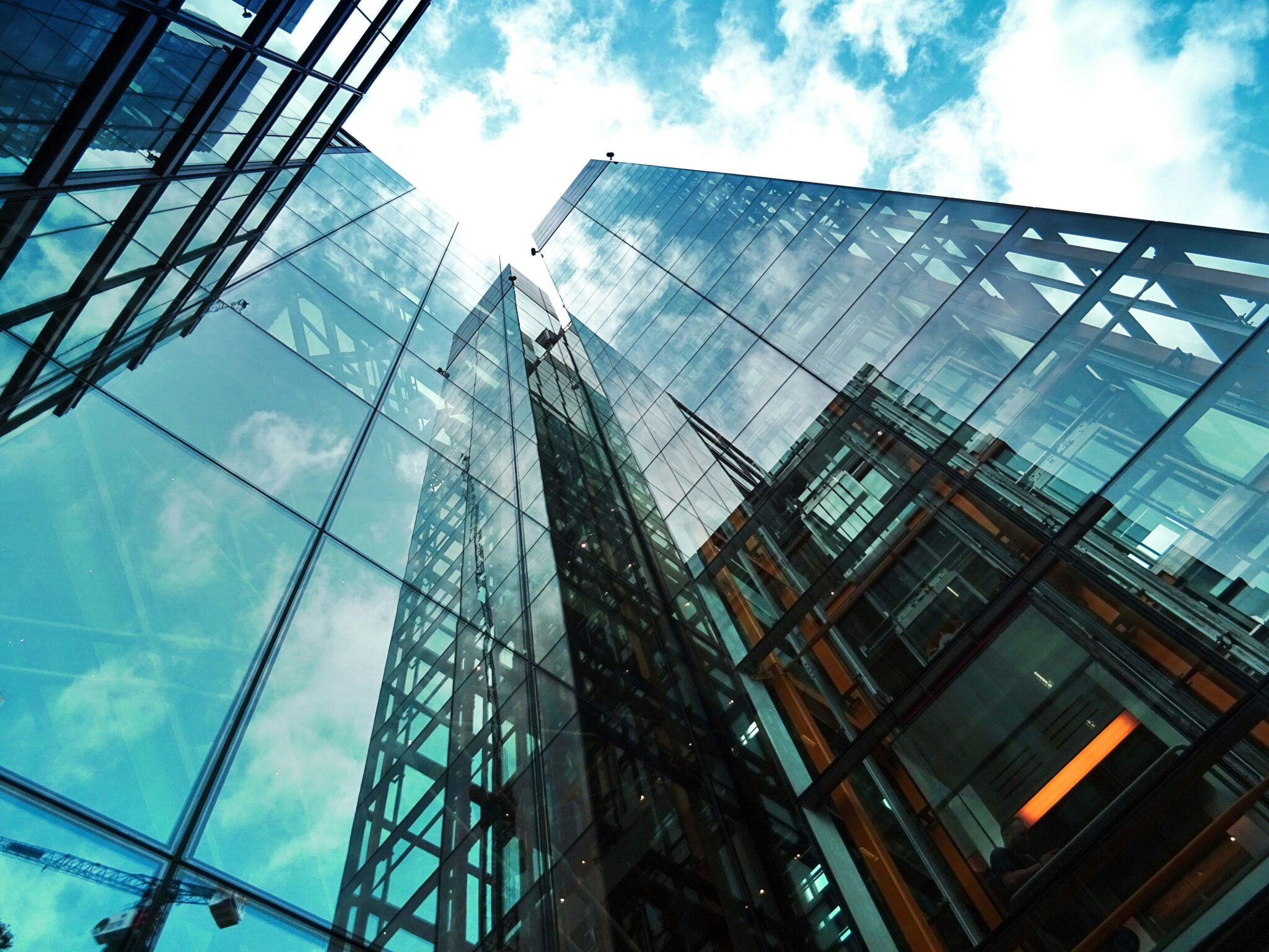 worms eye view of glass-front buildings and cloudy sky