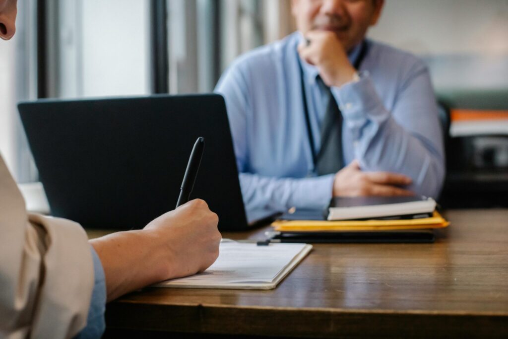 concept image of two people meeting at a desk, writing notes