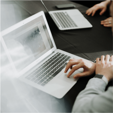 closeup of people's hands using laptops