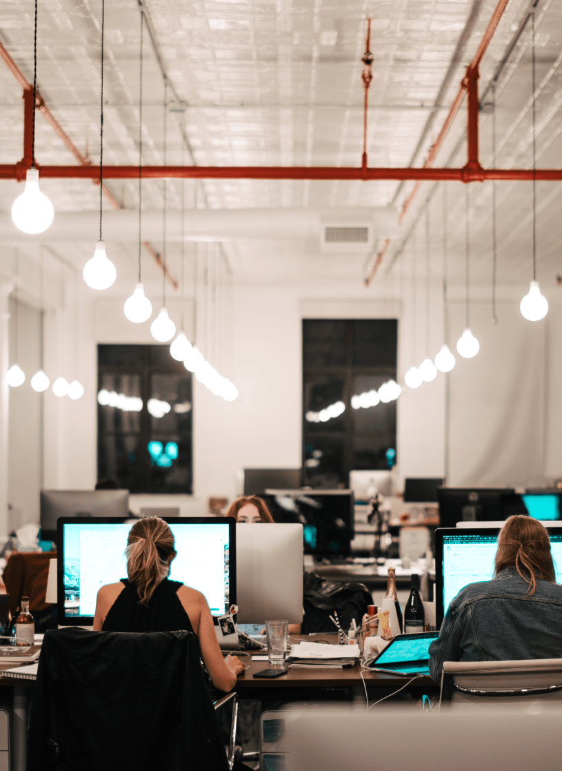interior industrial office with people working at large monitors